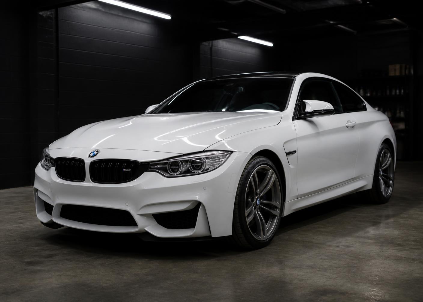 White coupe after paint correction under shop lights
